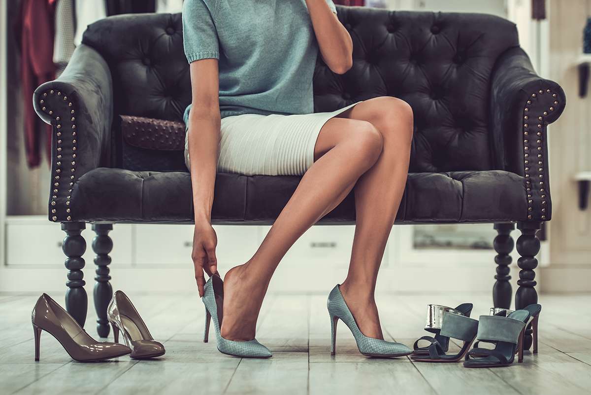 woman putting on gray high heels